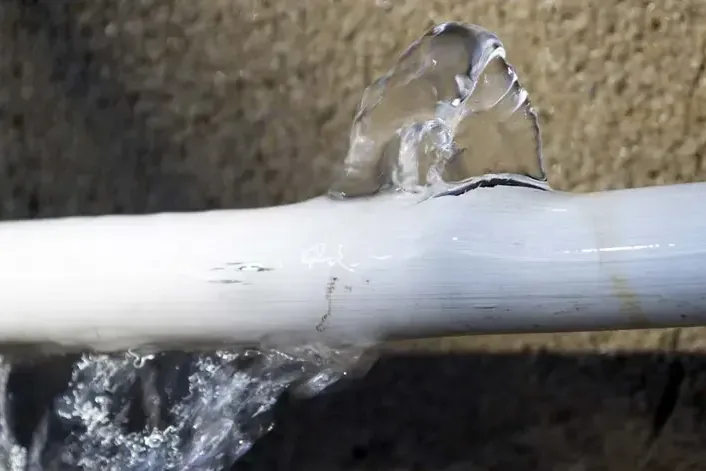 Water spraying from a split plastic supply pipe